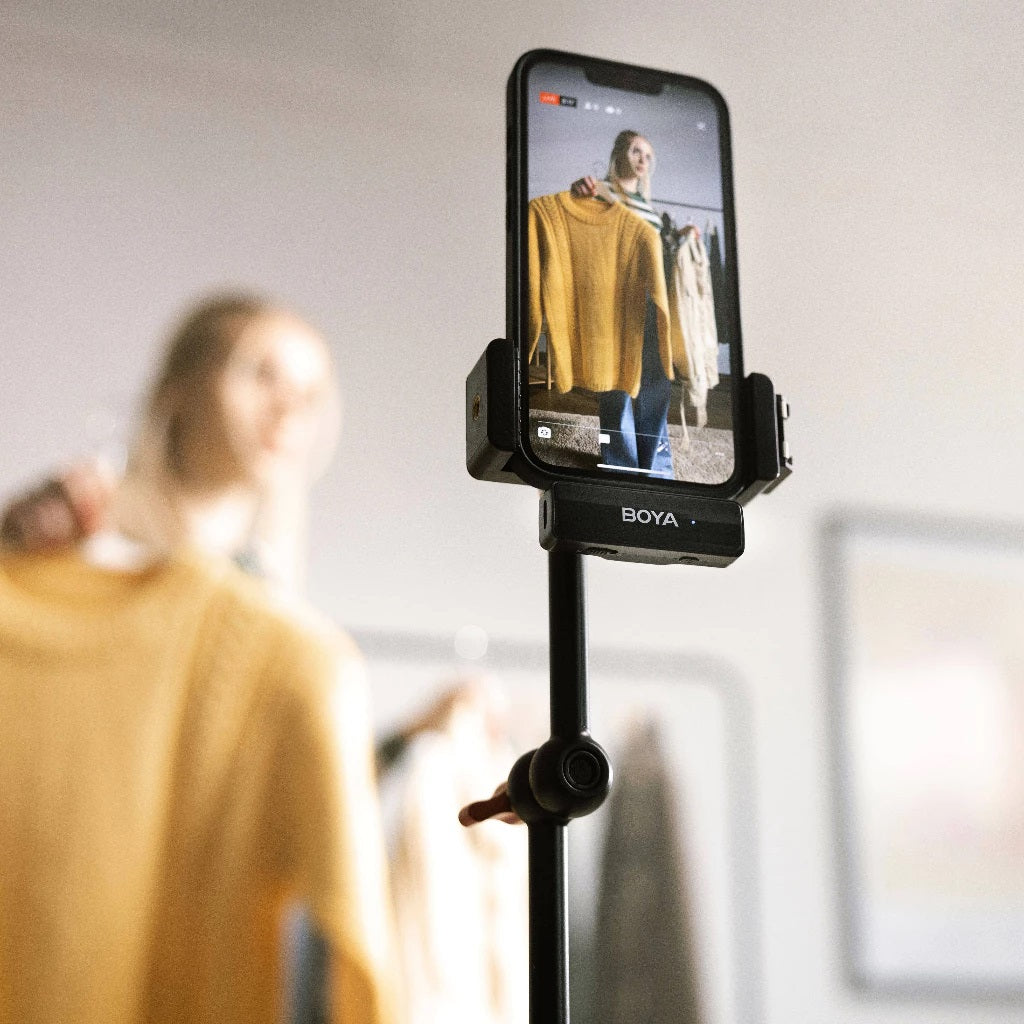 Content creator using a wireless lavalier microphone with charging box for video recording