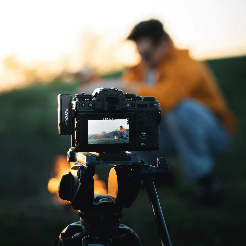 Wireless lavalier microphone with charging box mounted on a camera capturing outdoor scene