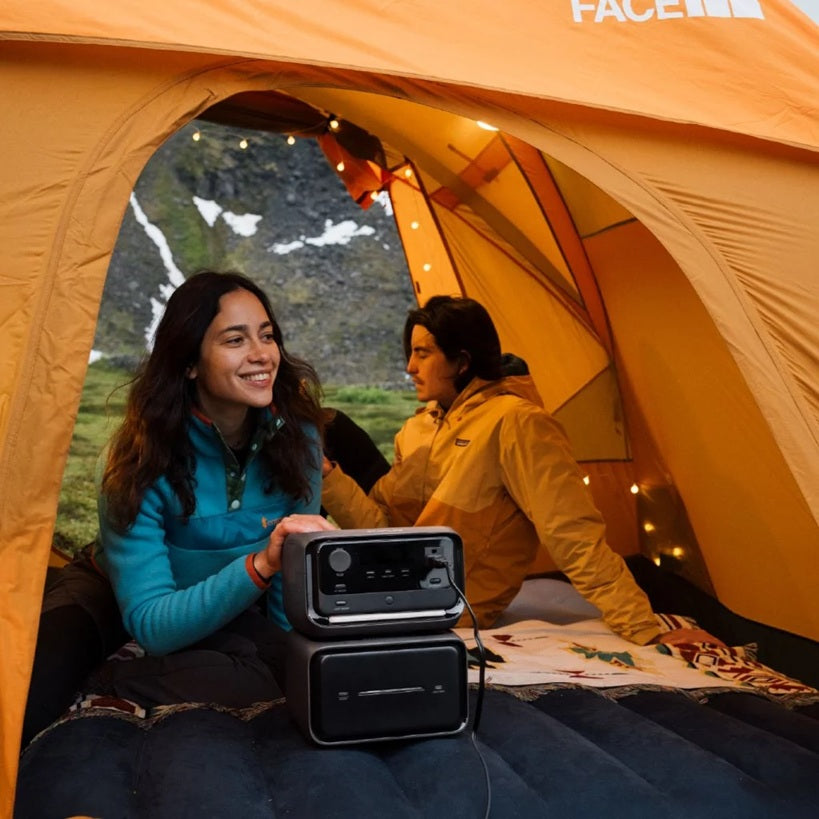 Ecoflow River 3 Max Plus Portable Power Station charging devices inside a camping tent with two people outdoors