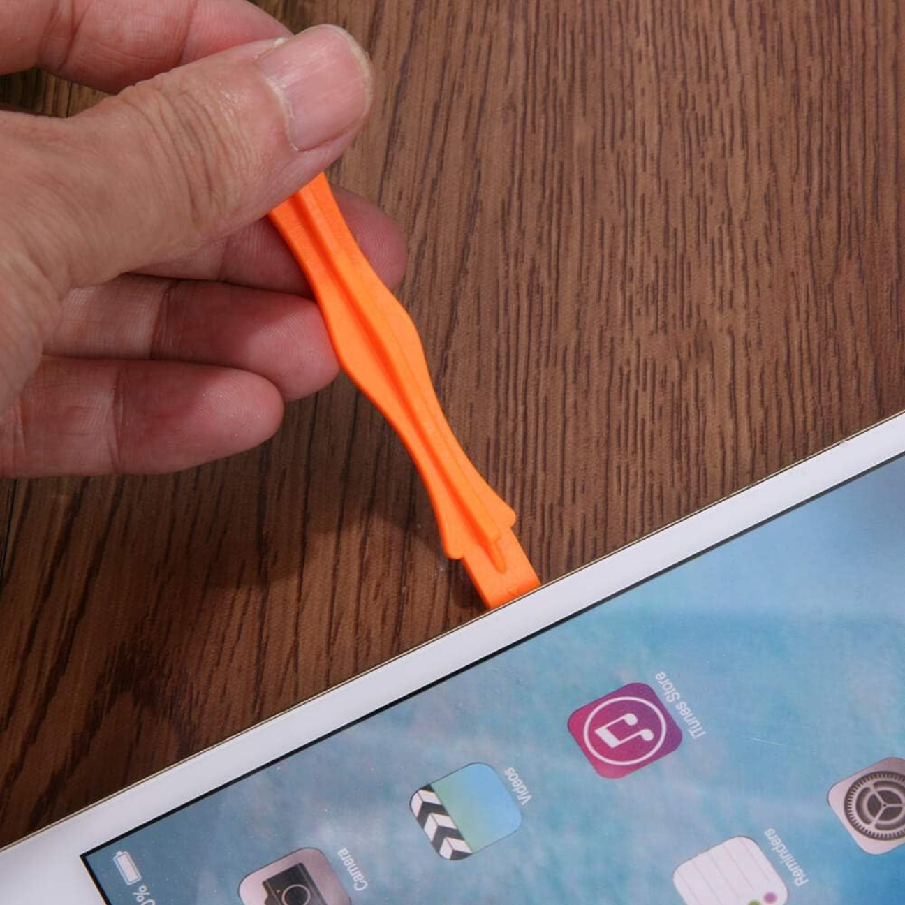 Professional phone repair tool kit featuring an orange prying tool for safe mobile device repairs