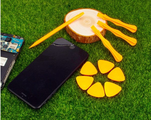 Professional phone repair tool kit with various tools for mobile phone repairs on green grass