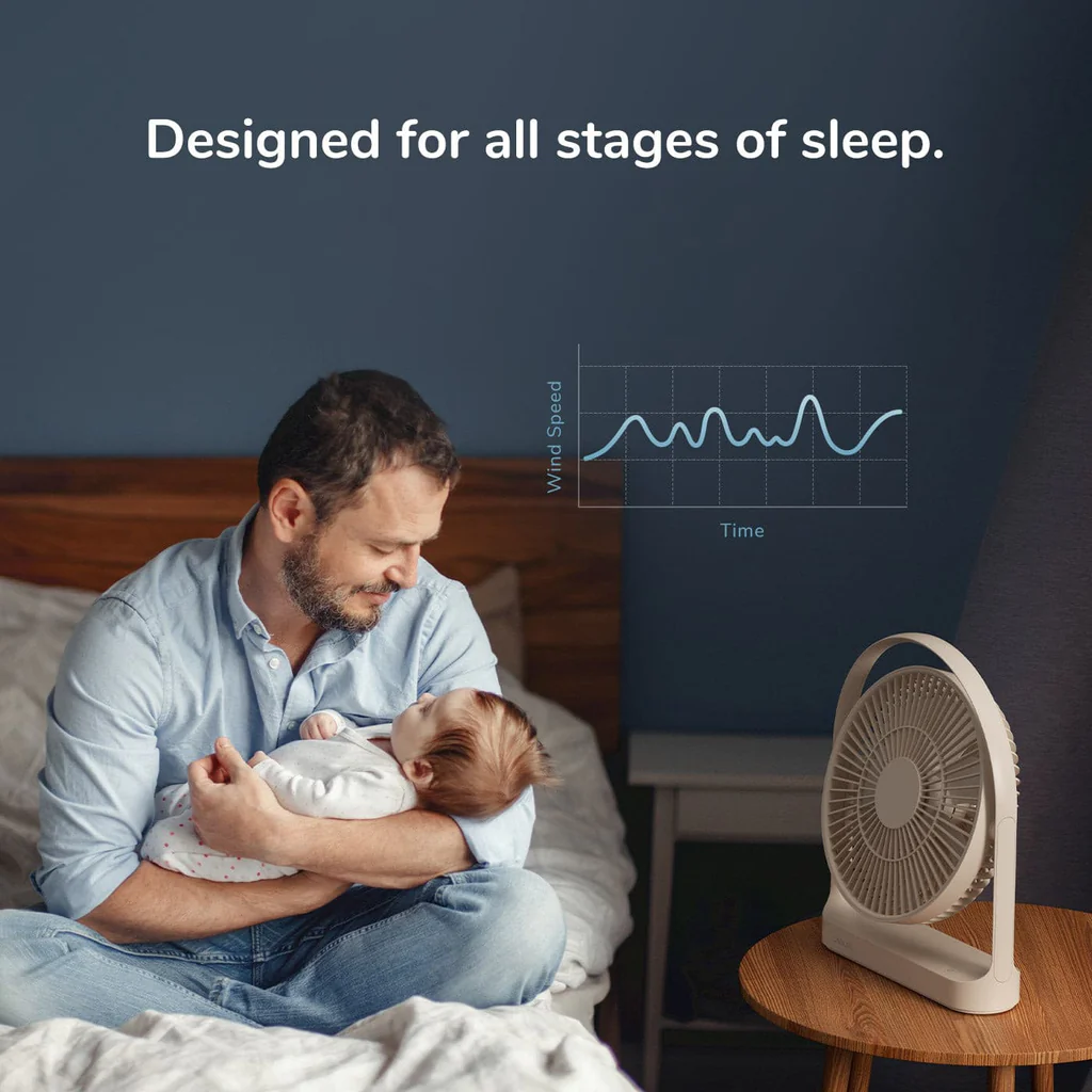 Portable rechargeable desk fan on bedside table with father holding baby in bedroom