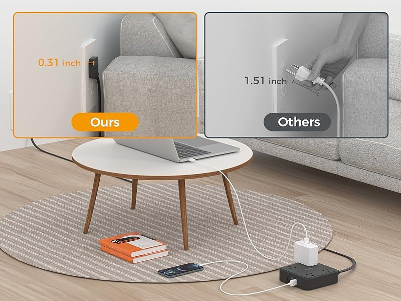 Flat plug power strip extension cord plugged into wall behind couch with laptop and phone charging