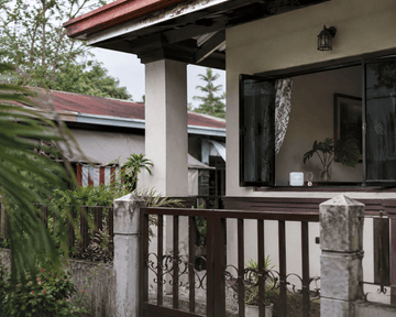 Filipino provincial home exterior representing a layered Daytech home safety setup for OFW families monitoring an elderly parent