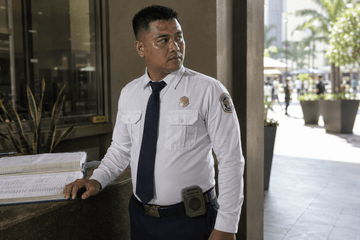 Filipino security guard wearing a 3Life waist clip fan on his belt during a hot Metro Manila shift