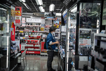 Person browsing electronics in a brightly lit store.