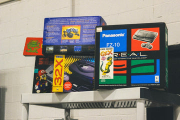 Stack of vintage video game console boxes on a shelf