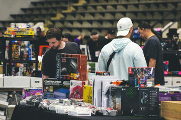 People browse video game consoles and merchandise at a market