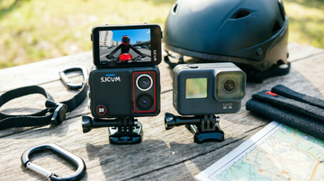 Two action cameras compared side by side on an outdoor table with adventure gear for a Philippines buyer comparison guide