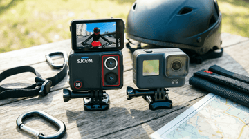 Two action cameras compared side by side on an outdoor table with adventure gear for a Philippines buyer comparison guide