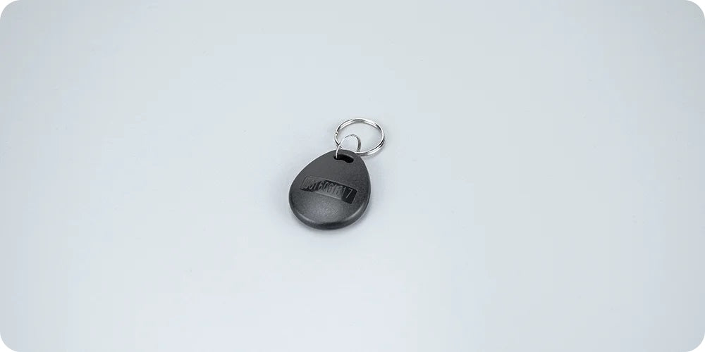 Black teardrop shaped Daytech RFID Tag Card with metal keyring on light gray background