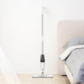 VMIDirect Water Spray Mop standing next to a bed on a hardwood floor for easy cleaning