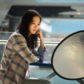 Model sitting at a table with a Diffuser Light Reflector enhancing natural lighting for photography