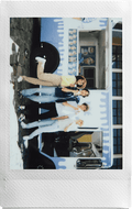 Group of friends posing in front of a colorful food truck with a Fujifilm Instax Mini camera