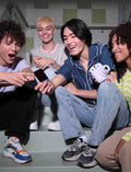 Group of friends enjoying photos taken with the Fujifilm Instax Mini camera in a fun setting
