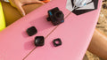 GoPro Max Lens Mod and accessories displayed on a pink surfboard for outdoor photography