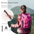 VMIDirect GXCT V200 2M Folding Tripod held by a woman with a backpack in a scenic outdoor setting