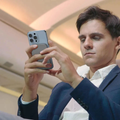 Man using a Magnetic Wireless Power Bank to charge his smartphone in a modern setting
