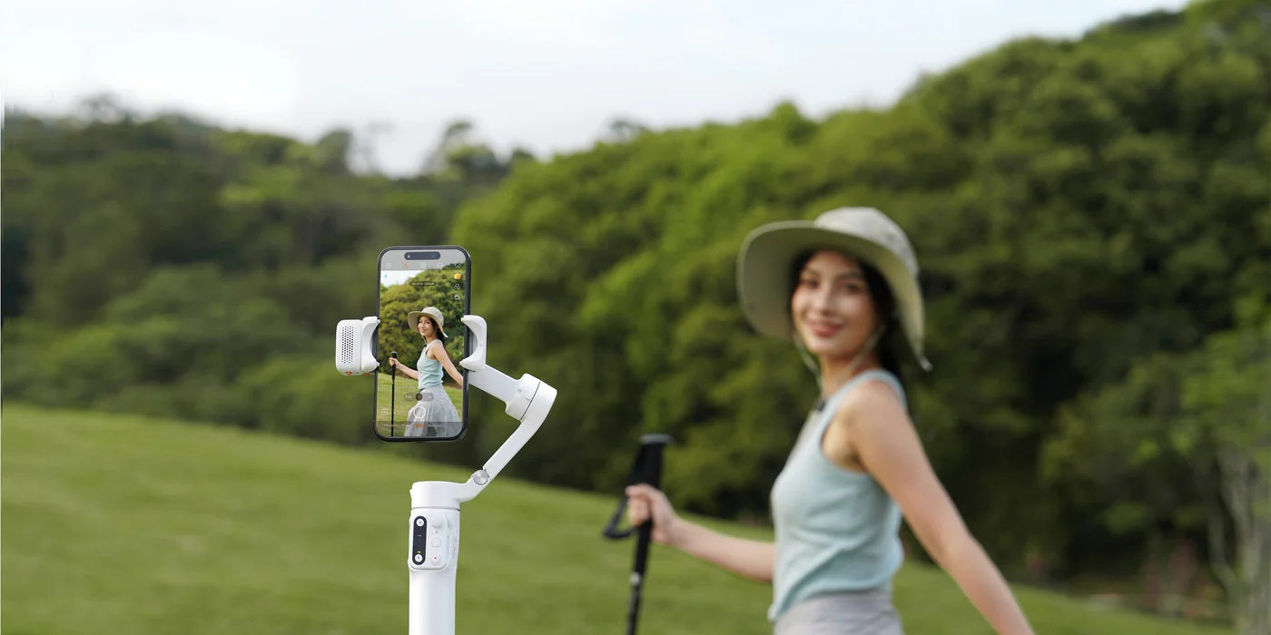 Woman using iSteady V3 Smartphone Gimbal while walking in a scenic outdoor setting