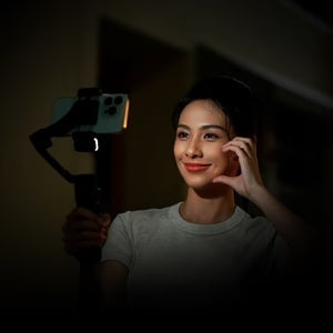 Woman using the iSteady V3 Smartphone Gimbal for smooth video recording in low light conditions