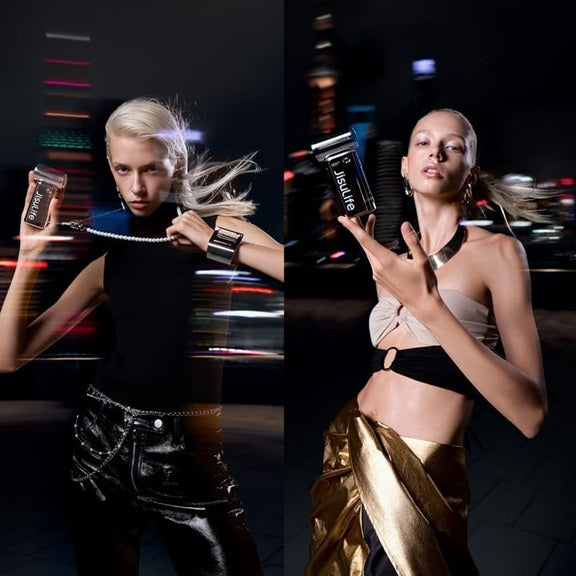 JISULIFE chrome handheld fan held by a model, showcasing its sleek design in a nighttime city backdrop
