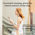 Woman using FA21 Portable Handheld Fan for cool comfort while shopping outdoors