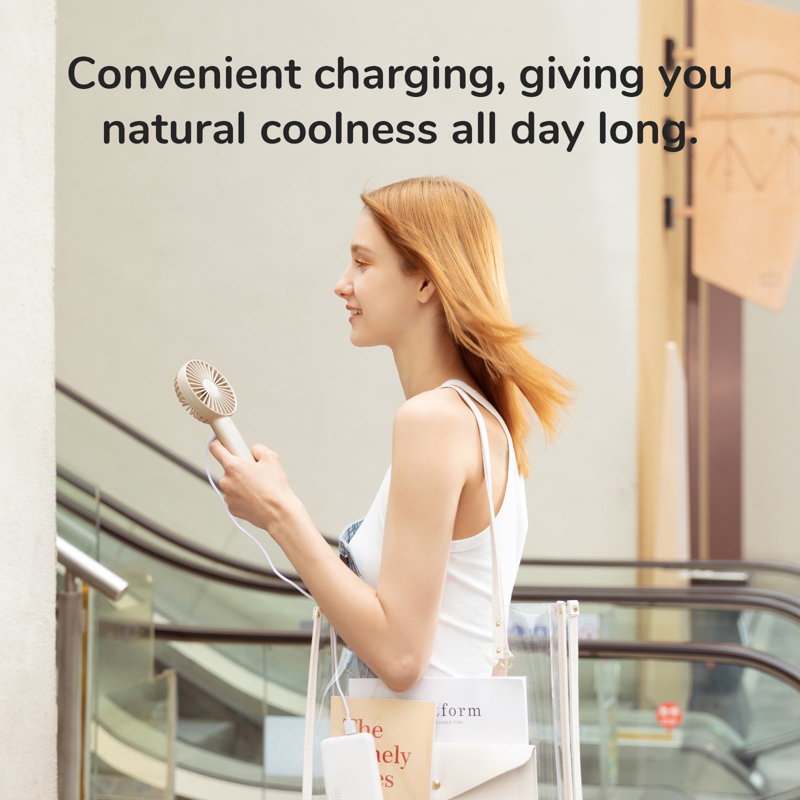 Woman using FA21 Portable Handheld Fan for cool comfort while shopping outdoors