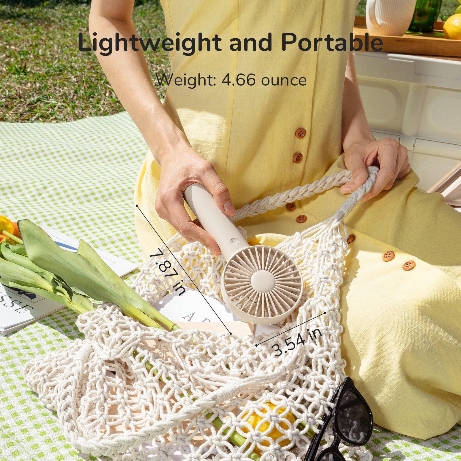 VMIDirect FA21 Portable Handheld Fan in a woman's hand while relaxing outdoors, showcasing lightweight design
