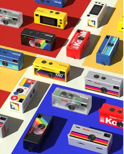 Various Kodak Charmera Mini Digital Camera models in vibrant colors displayed on a colorful background