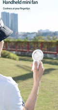 VMIDirect portable fan in hand outdoors, perfect for staying cool on-the-go