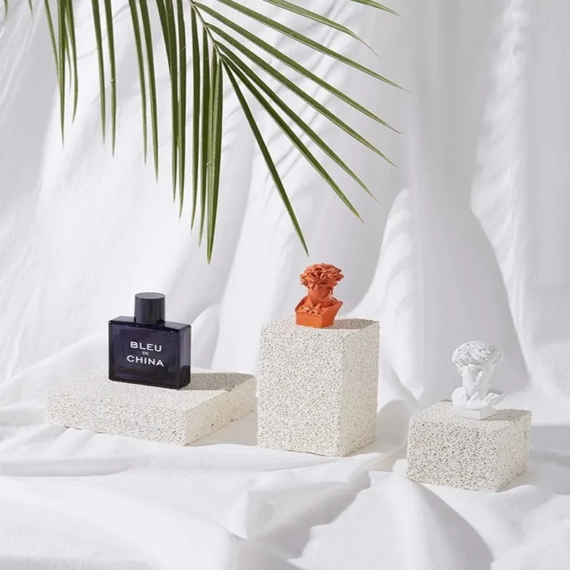 Display of Natural Stone Props with decorative items on textured white fabric backdrop