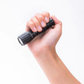A person holding a Tactical Waterproof Rechargeable Flashlight with a durable design for outdoor use.