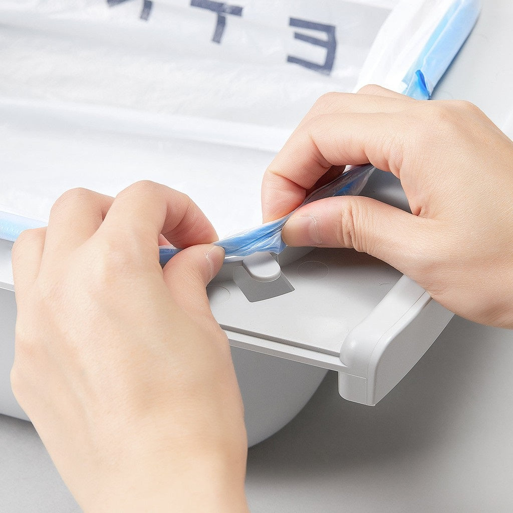 Hands attaching a Portable Cat Litter Waste Receptacles Bag to a litter box for easy disposal