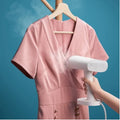 VMIDirect Portable Garment Steamer removing wrinkles from a pink dress on a hanger