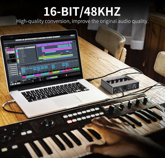 Professional audio interface with monitoring connected to a laptop and music keyboard