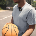 User wearing the Rode Wireless ME Microphone System while holding a basketball on a court