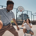 Young man playing basketball wearing a Rode Wireless ME Microphone System while a friend captures the moment