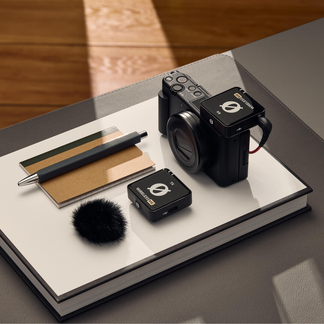 Rode Wireless ME Microphone System placed next to a camera and accessories on a coffee table