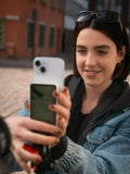 Young woman using selfie monitor screen for capturing perfect selfies outdoors