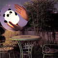 Cute panda design bedroom lamp on a patio table with hands gently holding it