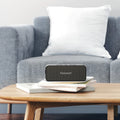 Tronsmart Bluetooth Speaker on a coffee table with books, designed for clear sound and portability