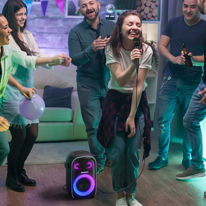 Group of friends enjoying a fun night with a Portable Party Speaker Karaoke during a lively celebration