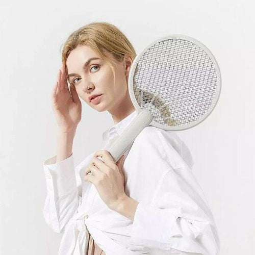 Woman holding USB rechargeable mosquito swatter in a stylish outfit for effective bug control