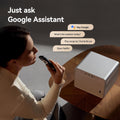 4K smart home projector on wooden table with woman using remote and Google Assistant voice commands