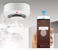 Home security alarm system with wireless smoke detector connected to smartphone app
