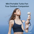 Woman using portable mini handheld fan with anti-lost lanyard outdoors on clear day