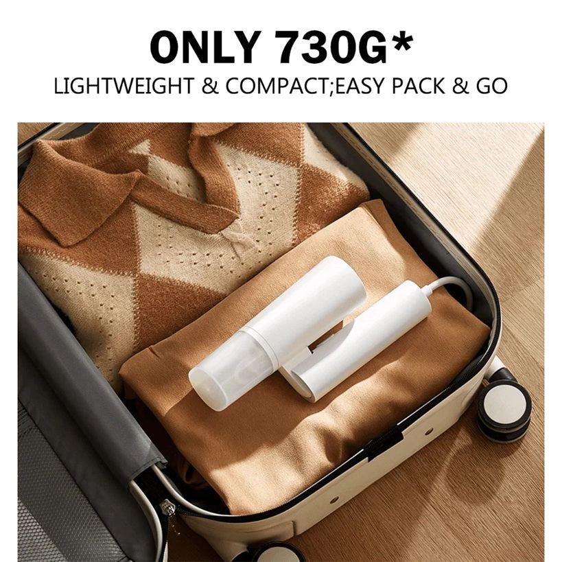 VMI Direct Portable Fabric Iron in a suitcase with folded clothes, showcasing its lightweight design