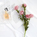 Artificial Flowers Silk Pink Roses Arrangement Next to Perfume Bottle and Magazine for Home Decor