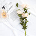 Artificial Flowers Silk Peony Bouquet arranged next to a perfume bottle on a white surface