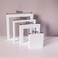 Set of four white cube photography backdrops in various sizes for versatile studio lighting